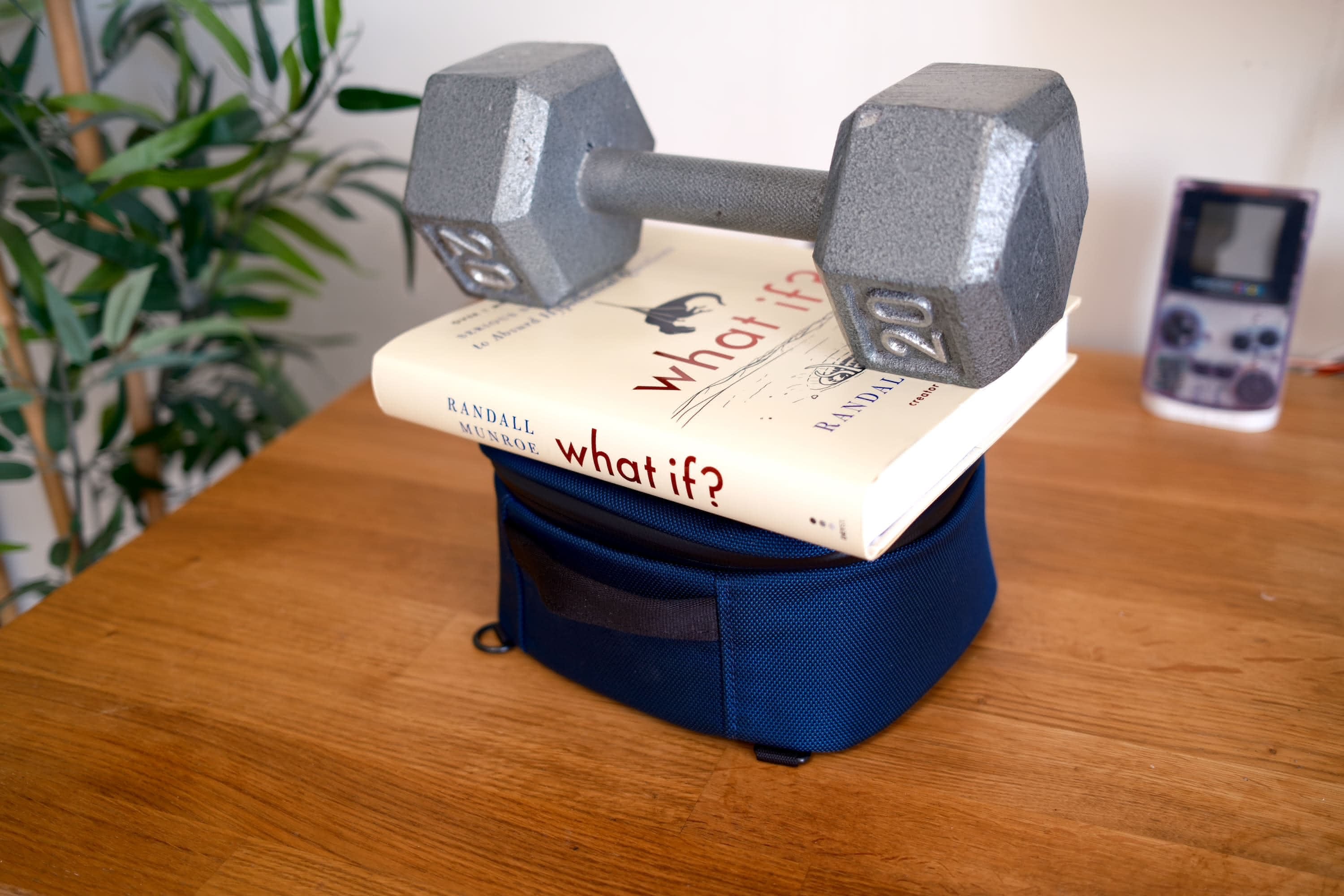 Dumbbell sitting on top of a book ('what if?' by Randall Monroe) sitting on top of the case showing no deforming.