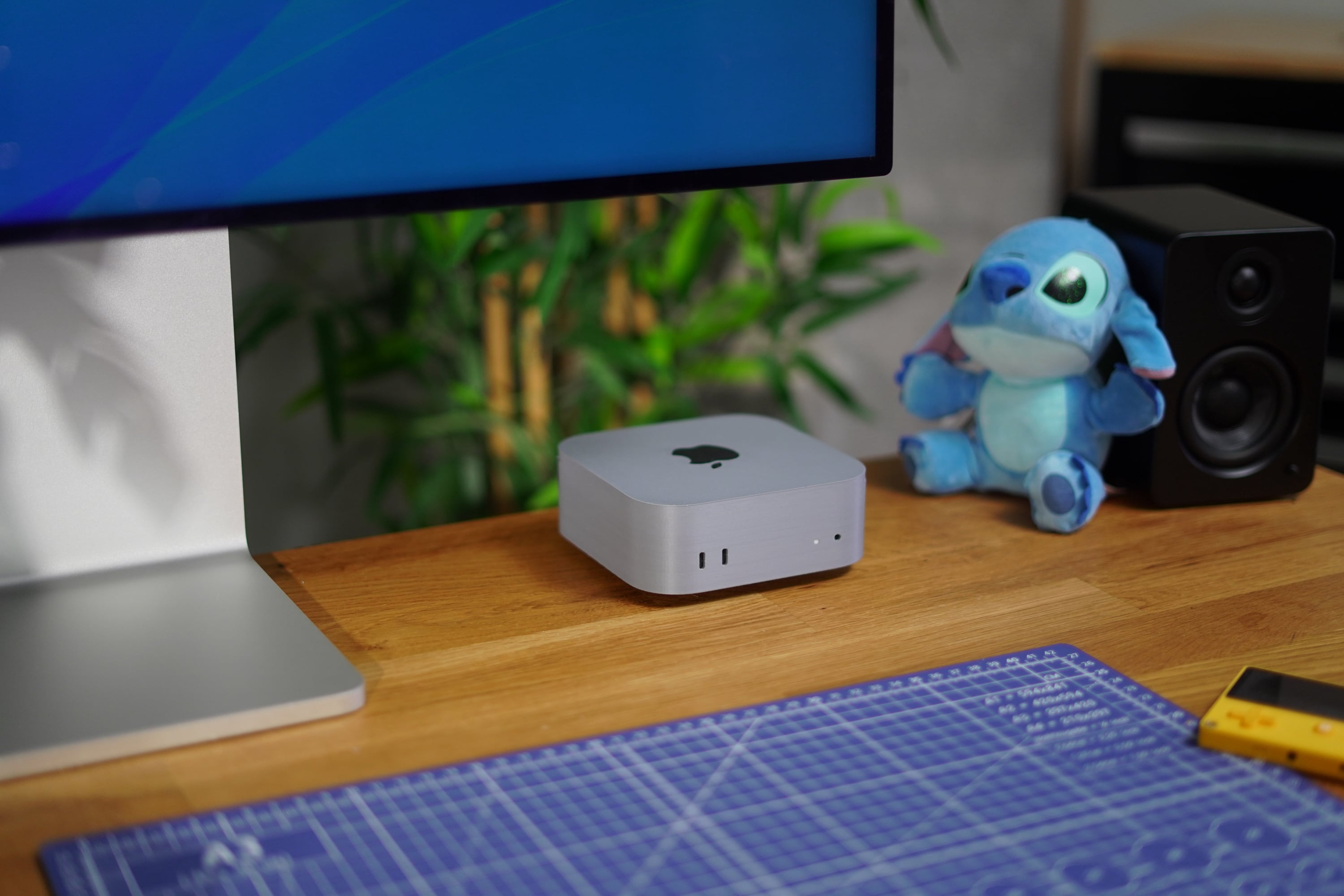 A 3D printed Mac mini sitting on an oak desk with a Stitch plushy sitting next to it