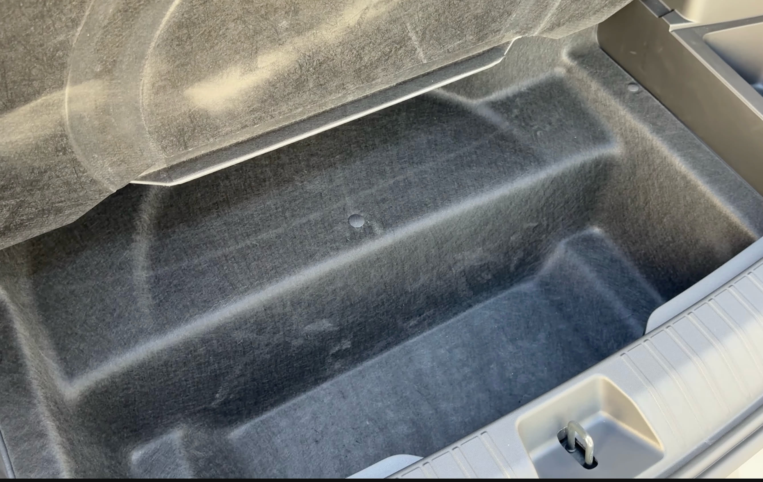 Empty space for a compact spare tire in the trunk of the Rivian R2